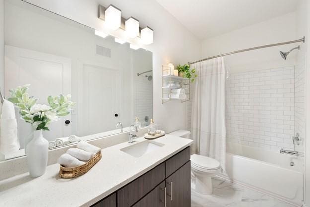 full bathroom with toilet, vanity, and shower / bath combo