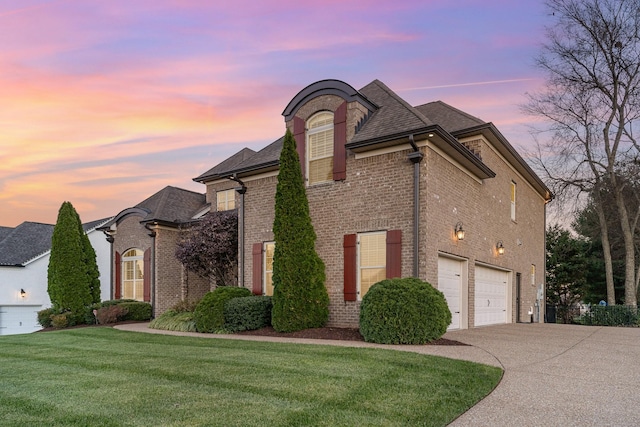 property exterior at dusk featuring a garage and a lawn