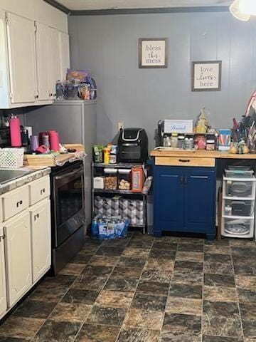 kitchen with white cabinets, range with electric cooktop, and blue cabinetry