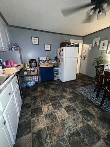 kitchen featuring ceiling fan, white cabinetry, crown molding, and white fridge