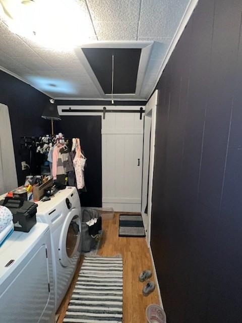 laundry room featuring separate washer and dryer and light hardwood / wood-style flooring