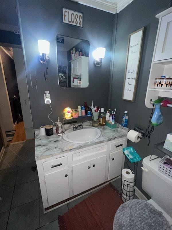 bathroom with toilet, crown molding, tile patterned floors, and vanity