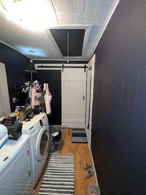 clothes washing area with washer and dryer and light wood-type flooring