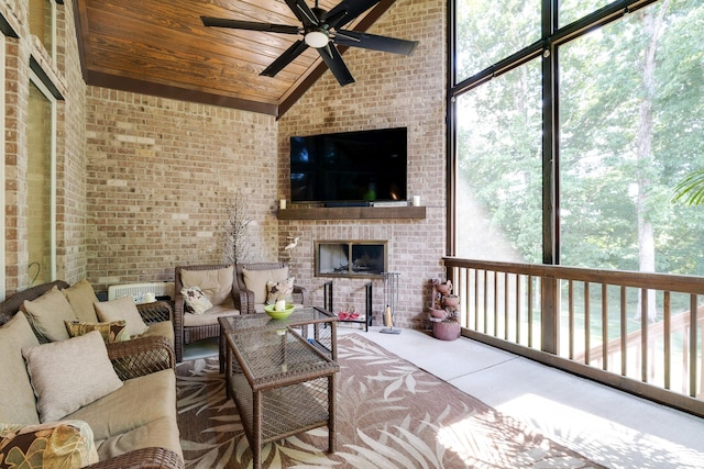 interior space featuring floor to ceiling windows, a fireplace, high vaulted ceiling, ceiling fan, and wooden ceiling