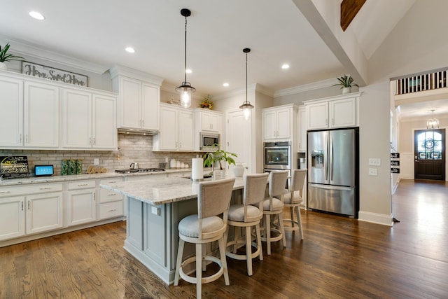 kitchen featuring a center island with sink, appliances with stainless steel finishes, white cabinets, hanging light fixtures, and light stone counters