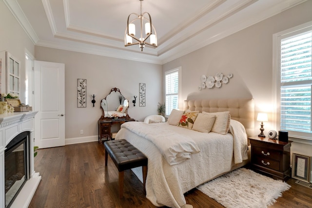 bedroom featuring ornamental molding, dark hardwood / wood-style flooring, a raised ceiling, and a chandelier