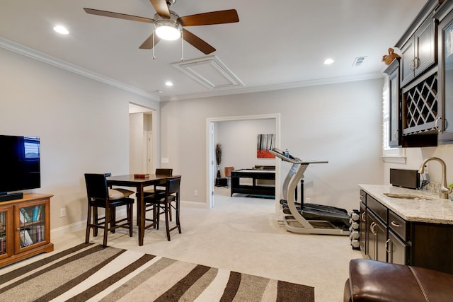 dining room featuring light carpet, ceiling fan, ornamental molding, and sink