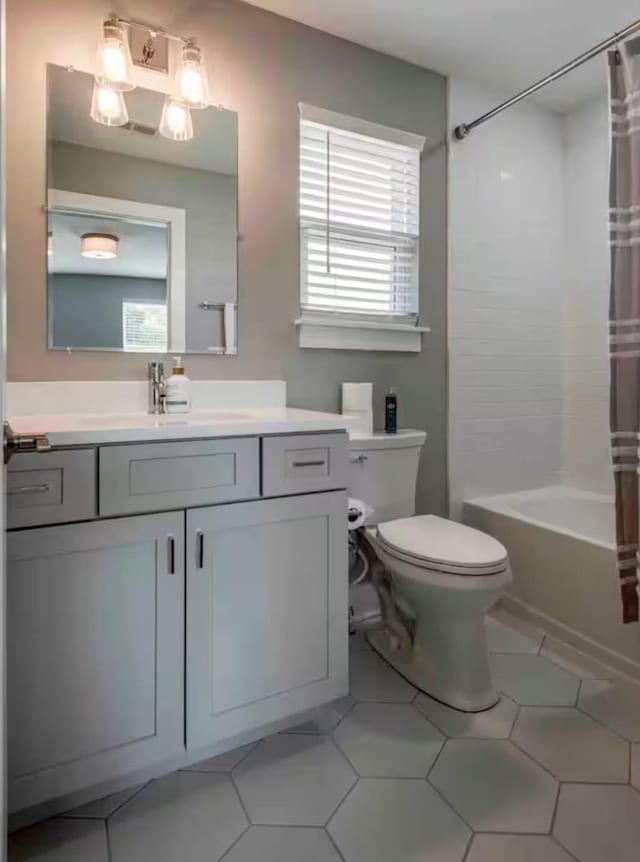 full bathroom featuring toilet, vanity, tile patterned floors, and shower / bath combination with curtain