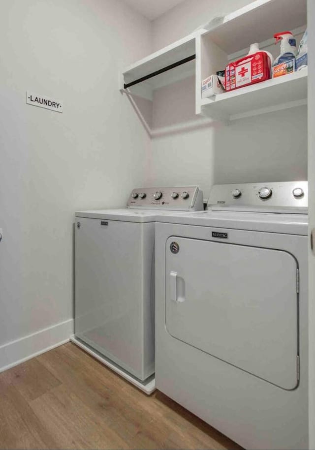 laundry room featuring separate washer and dryer and hardwood / wood-style floors