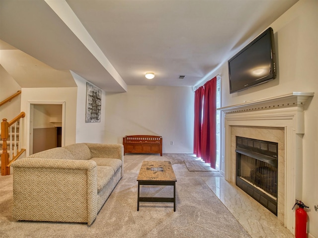 living room with a high end fireplace and carpet