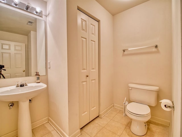 bathroom featuring toilet, tile patterned floors, and sink