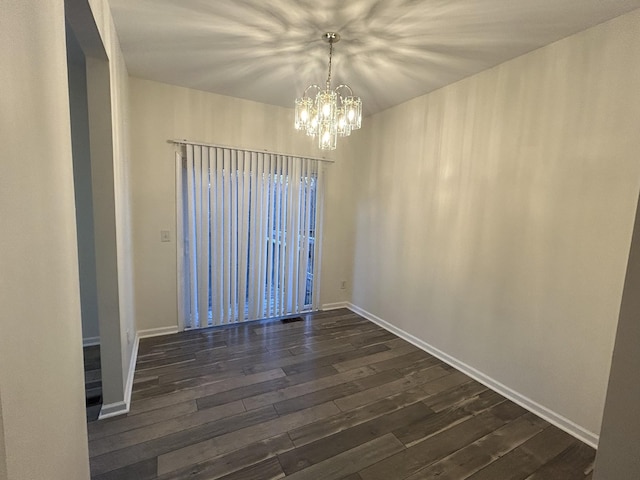 unfurnished room featuring dark hardwood / wood-style floors and a notable chandelier