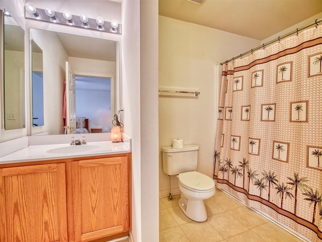 bathroom with toilet, tile patterned flooring, walk in shower, and vanity