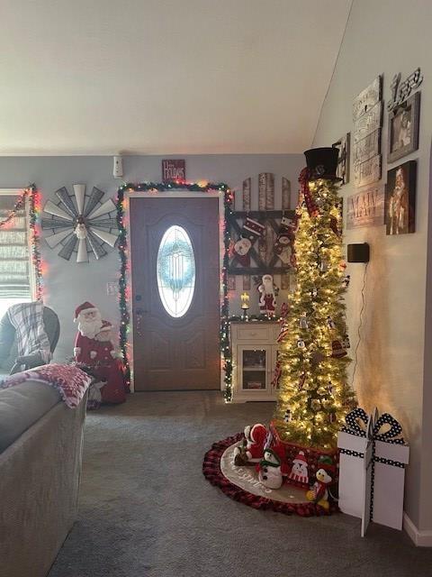 entrance foyer featuring carpet floors and vaulted ceiling