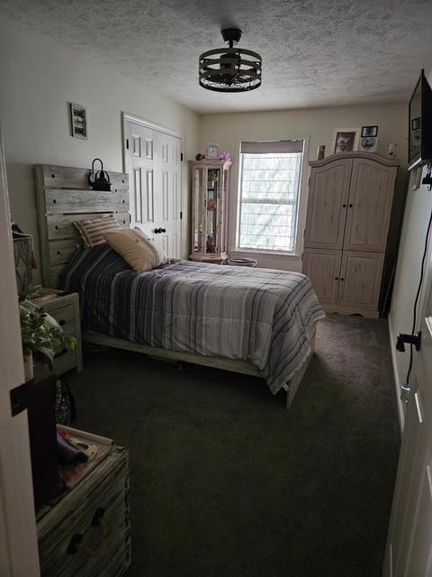 carpeted bedroom with a textured ceiling