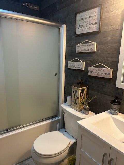 full bathroom with toilet, vanity, and combined bath / shower with glass door