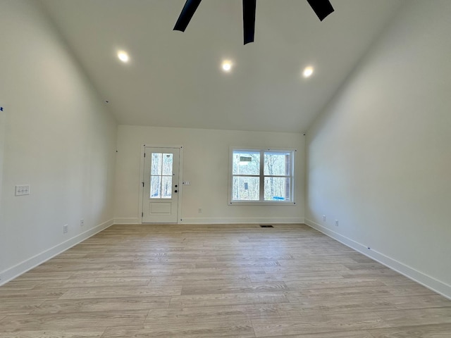 empty room with ceiling fan, light wood-type flooring, and high vaulted ceiling