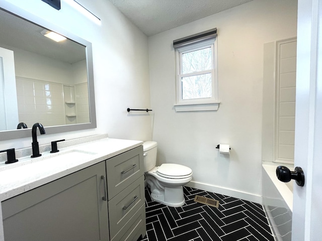 bathroom with toilet, a textured ceiling, tile patterned floors, and vanity