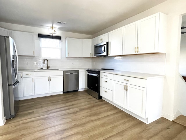 kitchen featuring light hardwood / wood-style floors, sink, white cabinetry, and appliances with stainless steel finishes