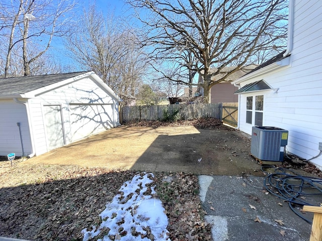 view of yard with a garage, an outbuilding, and central AC