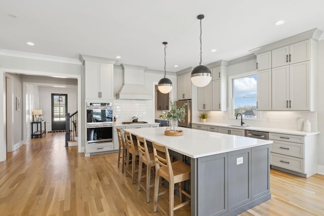 kitchen with a center island, stainless steel appliances, decorative backsplash, premium range hood, and a kitchen breakfast bar