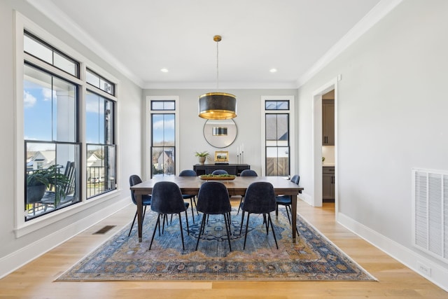 dining space featuring ornamental molding and light hardwood / wood-style floors