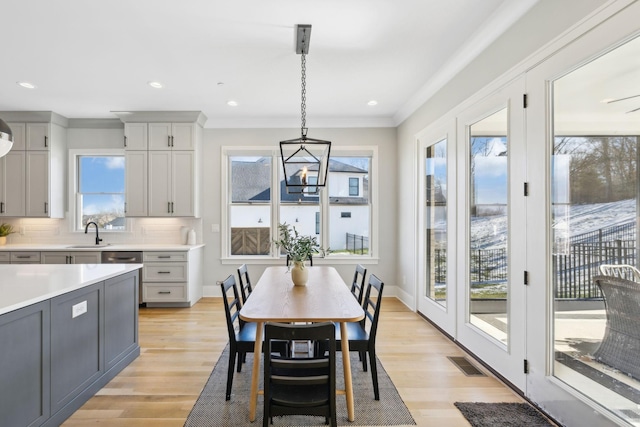 dining area featuring a healthy amount of sunlight, light wood-type flooring, and sink