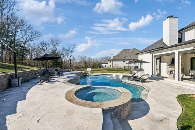 view of pool featuring an in ground hot tub, pool water feature, and a patio