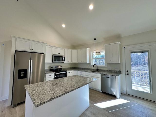 kitchen featuring pendant lighting, white cabinets, a kitchen island, stainless steel appliances, and sink