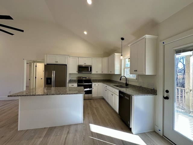 kitchen featuring white cabinets, appliances with stainless steel finishes, sink, and a kitchen island