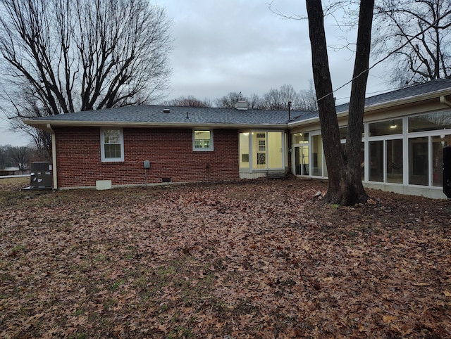 rear view of property with cooling unit and a sunroom