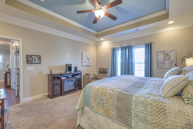 bedroom featuring ceiling fan, crown molding, and a tray ceiling