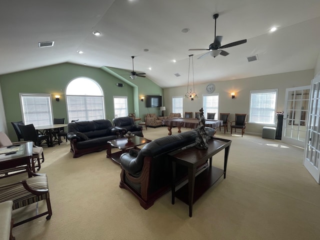 carpeted living room with ceiling fan, vaulted ceiling, and a wealth of natural light