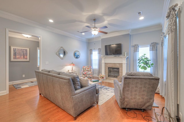 living room with light hardwood / wood-style floors, crown molding, and ceiling fan