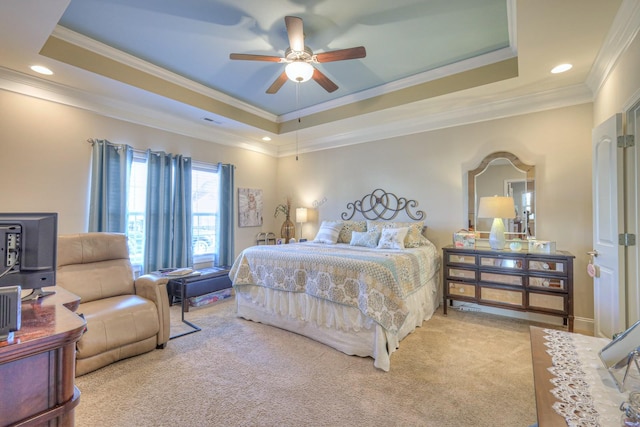 bedroom with ceiling fan, light colored carpet, a tray ceiling, and ornamental molding