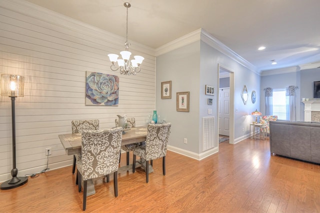 dining area with ornamental molding, hardwood / wood-style flooring, and a notable chandelier