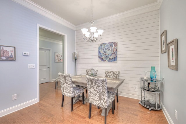 dining room featuring wood-type flooring, ornamental molding, and a chandelier