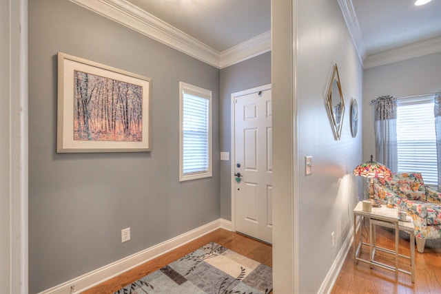 foyer entrance with wood-type flooring, a wealth of natural light, and crown molding