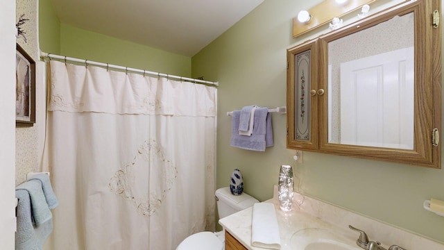 bathroom with curtained shower, toilet, and vanity