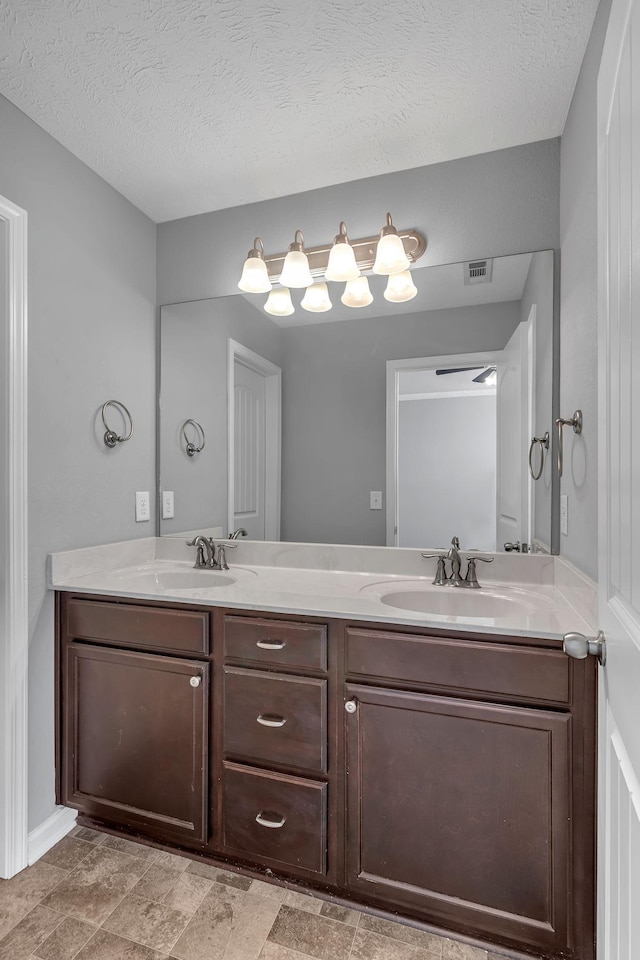 bathroom with a textured ceiling and vanity