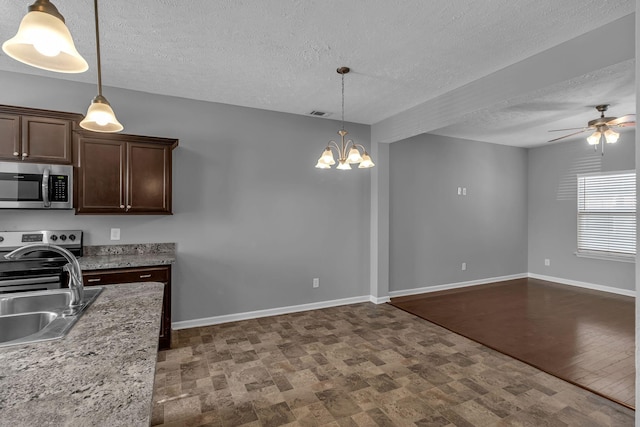 kitchen with decorative light fixtures, appliances with stainless steel finishes, sink, and dark brown cabinets