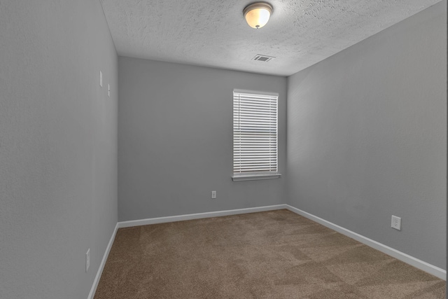 unfurnished room with carpet and a textured ceiling