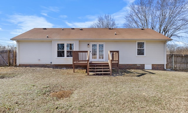 back of property with a wooden deck and a yard