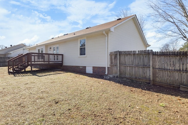 rear view of property featuring a deck and a lawn