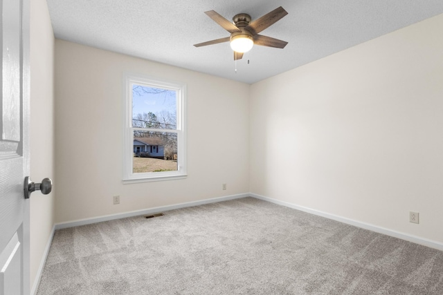 unfurnished room with light carpet, ceiling fan, and a textured ceiling