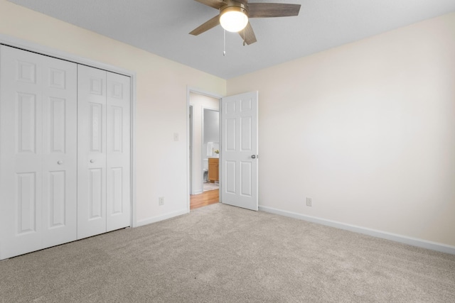 unfurnished bedroom featuring ceiling fan, a closet, and light carpet