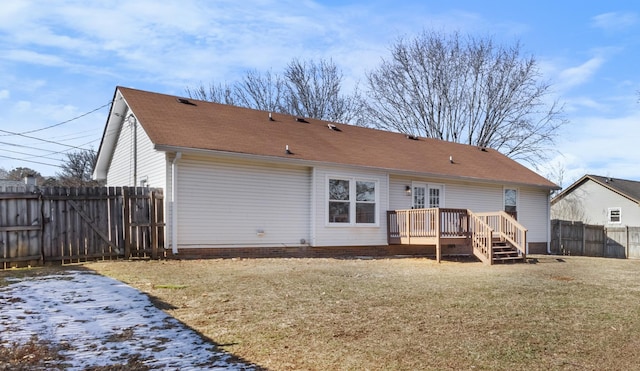 rear view of house featuring a wooden deck and a lawn