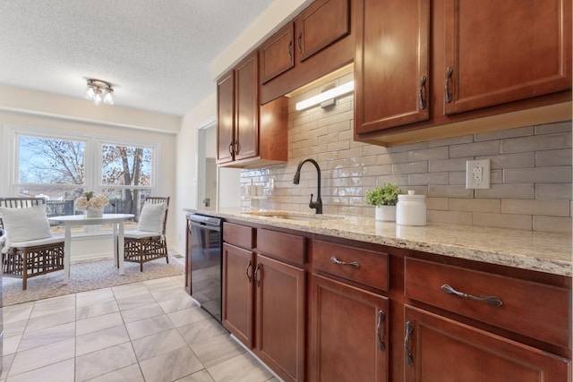 kitchen featuring black dishwasher, tasteful backsplash, light tile patterned flooring, light stone countertops, and sink