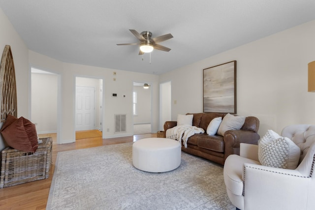 living room featuring ceiling fan and hardwood / wood-style floors