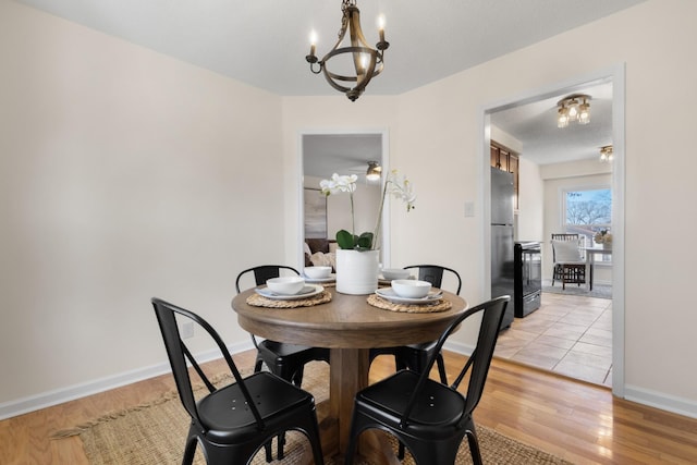 dining room with light wood-type flooring and a chandelier